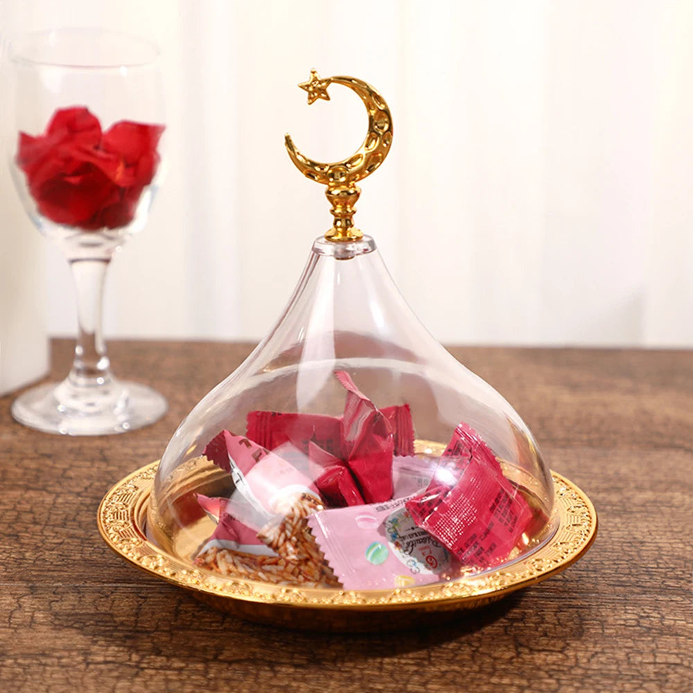 Une élégante cloche en verre avec un croissant et une étoile dorés contient des pétales de rose rouges sur un plateau doré, évoquant une atmosphère romantique et mystique.