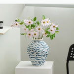 vase moderne blanc bleu rayures taches fleurs artificielles décoration intérieure unique table arrangement floral