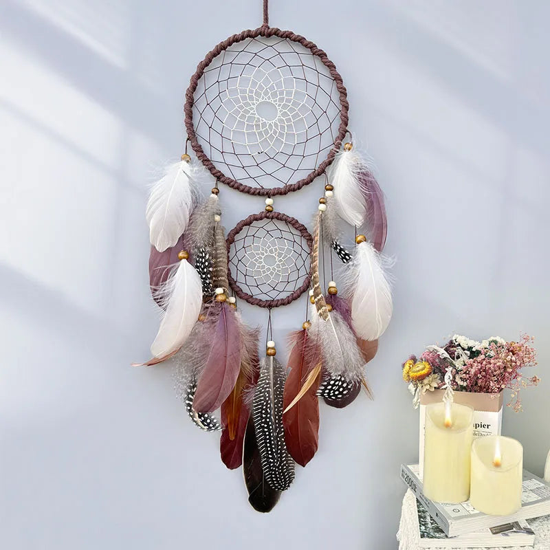 Un magnifique attrape-rêves orné de plumes multicolores, d'un motif en spirale et de petits accessoires dorés, créant une décoration murale élégante et apaisante.