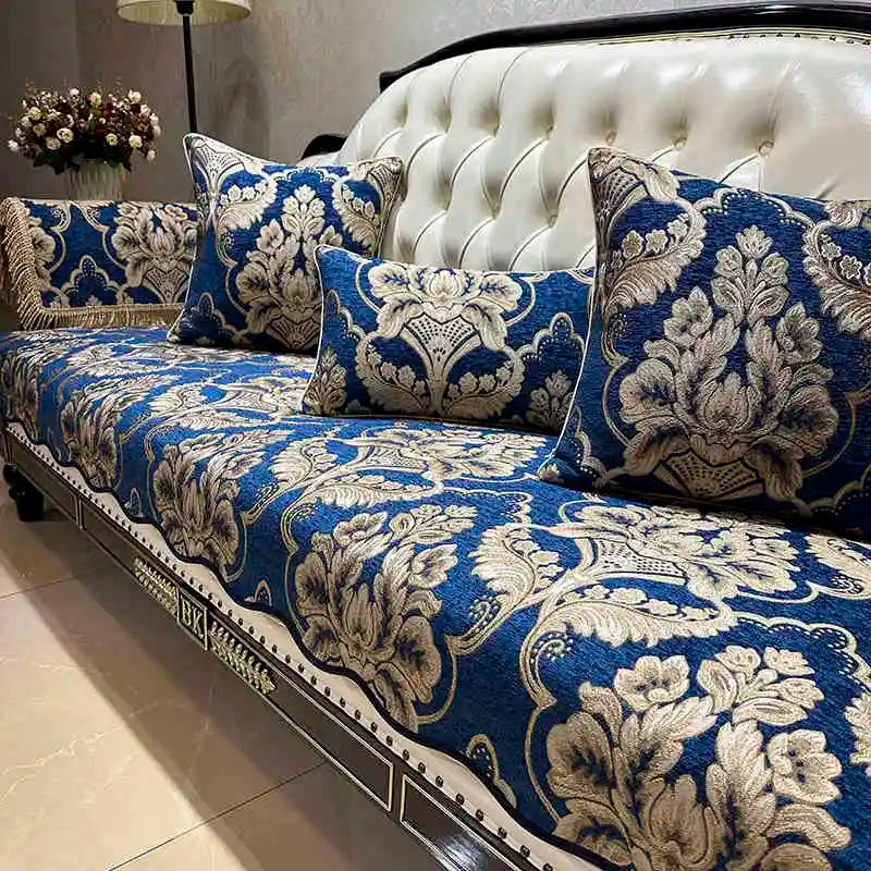 Un canapé bleu et blanc décoré de motifs floraux élégants, avec des coussins assortis, dans un intérieur chaleureux et luxueux.