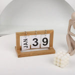 calendrier sculpture bois minimaliste moderne chiffres coulissants personne assise buste sphères blancs