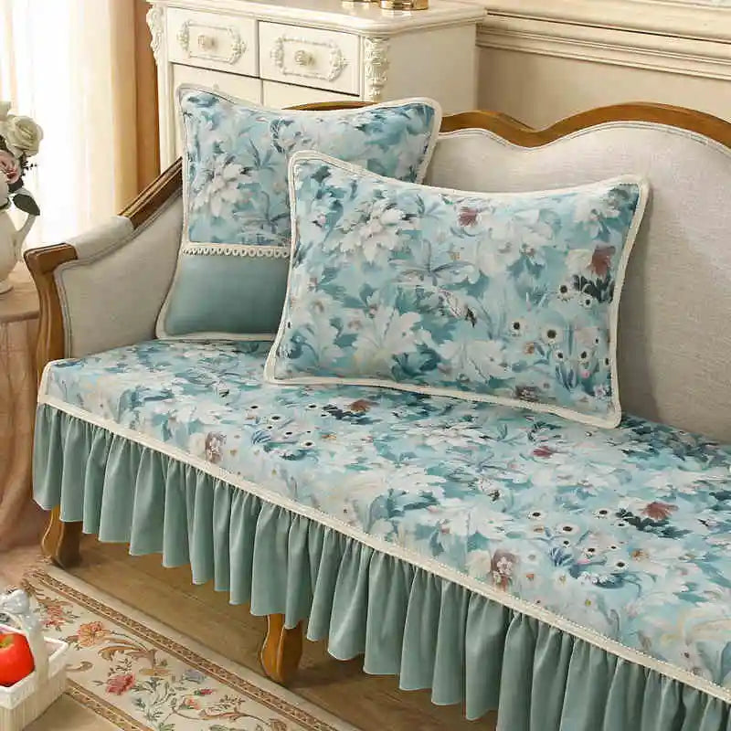 Un beau canapé vintage avec un motif floral bleu et blanc, orné de coussins assortis, dans une chambre élégante et accueillante.