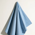 Une nappe bleu clair élégante et pliée, offrant une décoration subtile et raffinée pour une table.