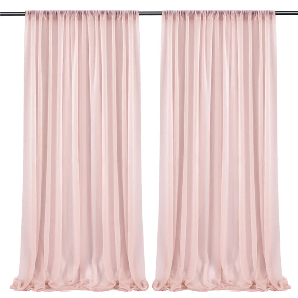 Deux longs rideaux de couleur rose pâle pendent sur une tringle noire.
