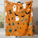 Une couverture orange décorée d'éléments d'Halloween comme des fantômes, des chauves-souris, des citrouilles et des crânes.