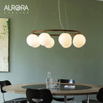 suspension lumineuse moderne câbles suspendus sphères translucides dorées blanches salon restaurant
