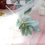 bouquet artificiel feuilles ovales vert clair gris rustique naturel vase transparent emballage brun serviette
