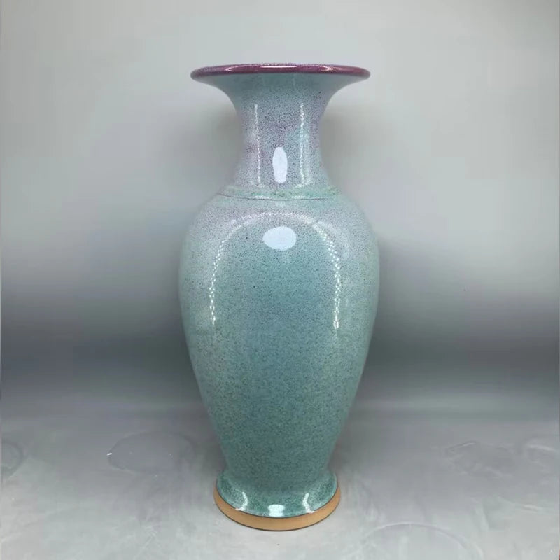 Vase en céramique de couleur vert clair avec des accents violets.