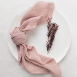 Ce foulard léger rose pâle avec une feuille de plante rougeâtre ajoute une touche de sophistication à la présentation.