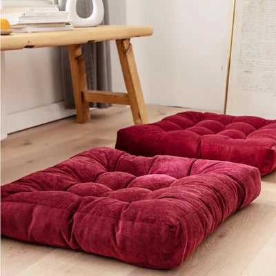 Coussin de sol carré rouge en velours côtelé sur un parquet