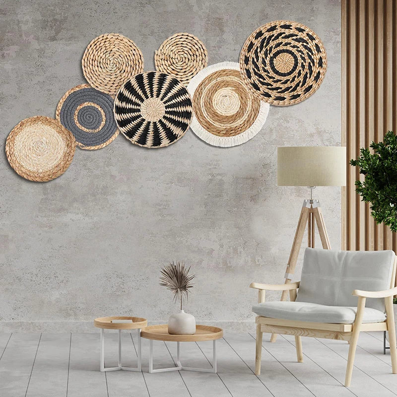 Décoration murale composée d'un arrangement de paniers tressés aux motifs géométriques dans des tons naturels, dans un intérieur moderne et épuré.