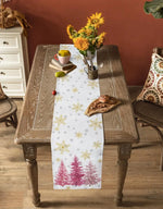 Une table en bois rustique avec une nappe blanche et des motifs hivernaux, ornée d'un bouquet de tournesols dans un vase et d'autres éléments décoratifs.