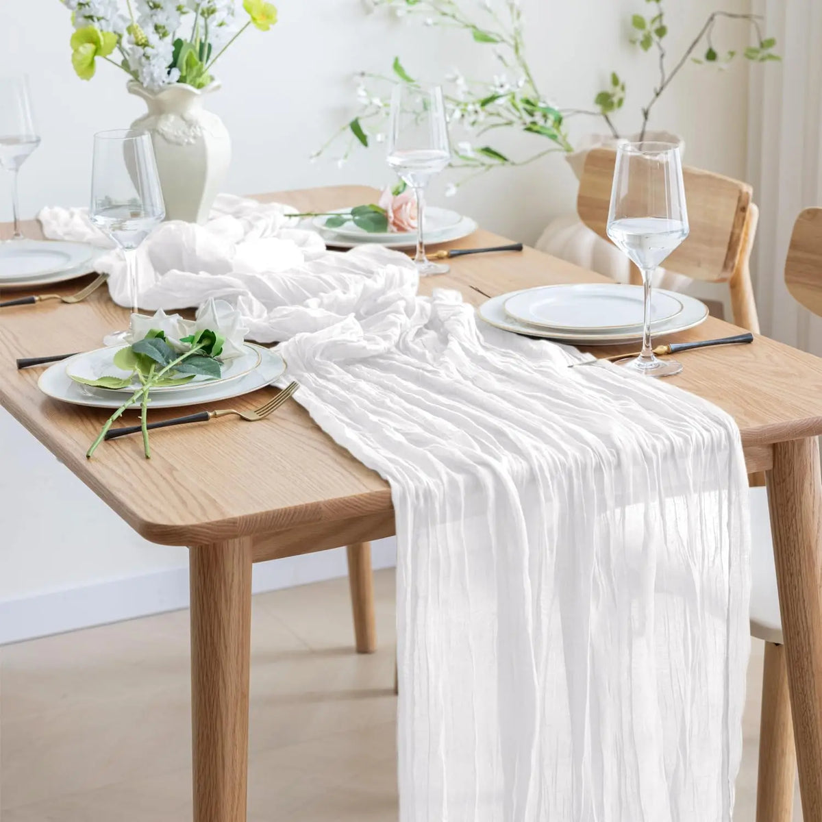 serviette table vert plissée moderne assiettes blanches verres vin bougies vase blanc pompons blancs