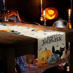 L'image montre une scène d'Halloween avec une boîte en bois décorée de citrouilles, de chauves-souris et d'un chat noir, ainsi que des bougies allumées, créant une atmosphère festive et mystérieuse.