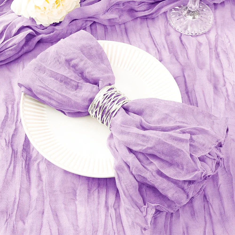 Une ravissante nappe en voile de couleur lavande, agrémentée d'un bouquet de fleurs blanches, créant une élégante mise en scène pour une table de fête.
