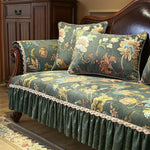 Un canapé de style vintage avec un tissu à motifs floraux luxuriants, complété par des coussins assortis et une jupe plissée sophistiquée, créant une atmosphère élégante et chaleureuse dans la pièce.