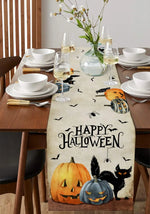 Table dressée pour la célébration d'Halloween, avec des verres de vin, des assiettes, des couverts et un chemin de table orné de citrouilles et de chats noirs. L'ensemble crée une ambiance festive et chaleureuse pour cette fête d'automne.