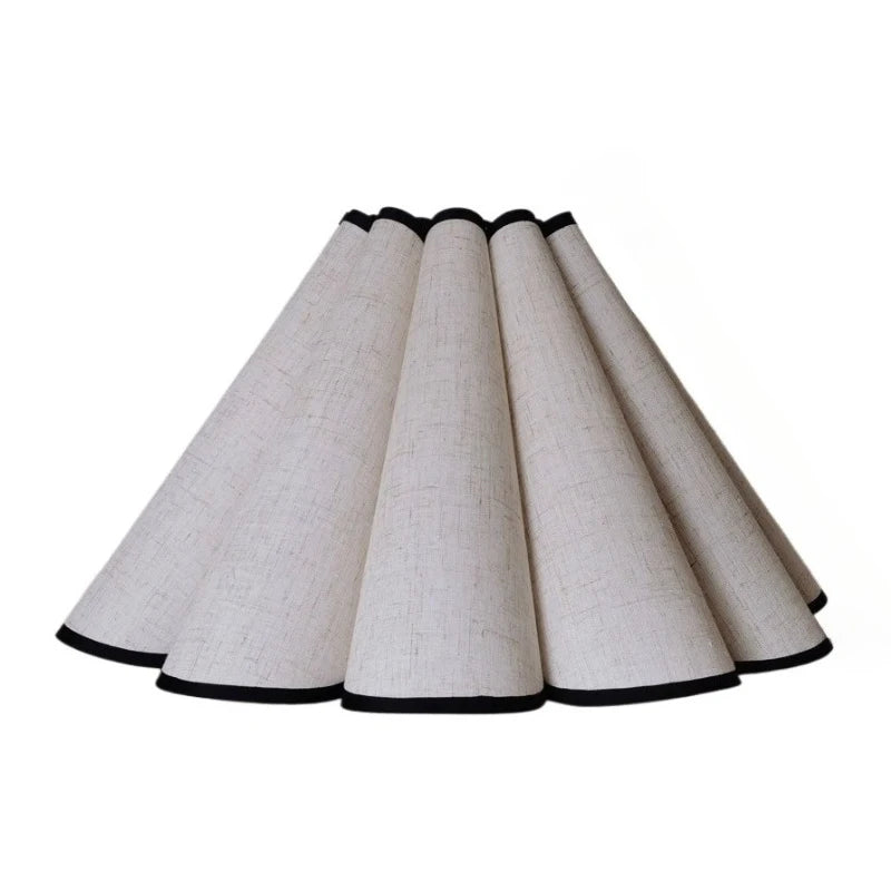 Abat-jour beige forme pétale sur table de nuit