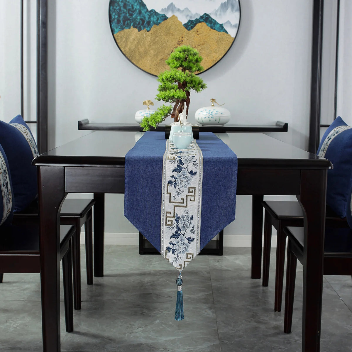 Intérieur moderne avec mobilier en bois sombre, décoration asiatique et miniature d'arbre dans un décor montagneux.