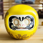 statuette japonaise daruma rouge blanche visage sourire yeux grands ouverts motifs dorés traditionnels décoration