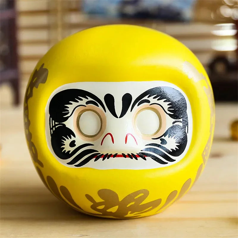 statuette japonaise daruma rouge blanche visage sourire yeux grands ouverts motifs dorés traditionnels décoration