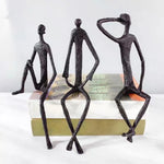 statues modernes minimalistes figures humaines assises noir texture brut forge lunettes livresintérieur