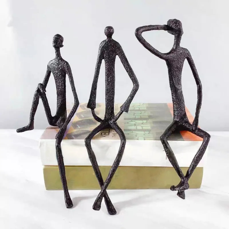 statues modernes minimalistes figures humaines assises noir texture brut forge lunettes livresintérieur