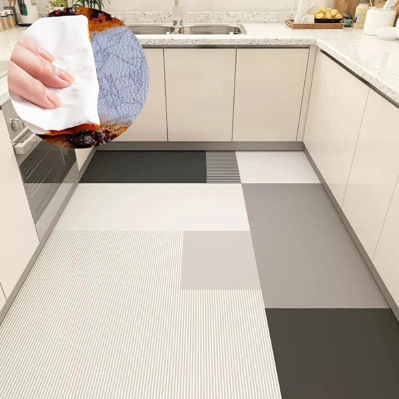 Le sol de la cuisine est composé de carreaux en céramique aux motifs géométriques en nuances de gris, créant une surface élégante et épurée.