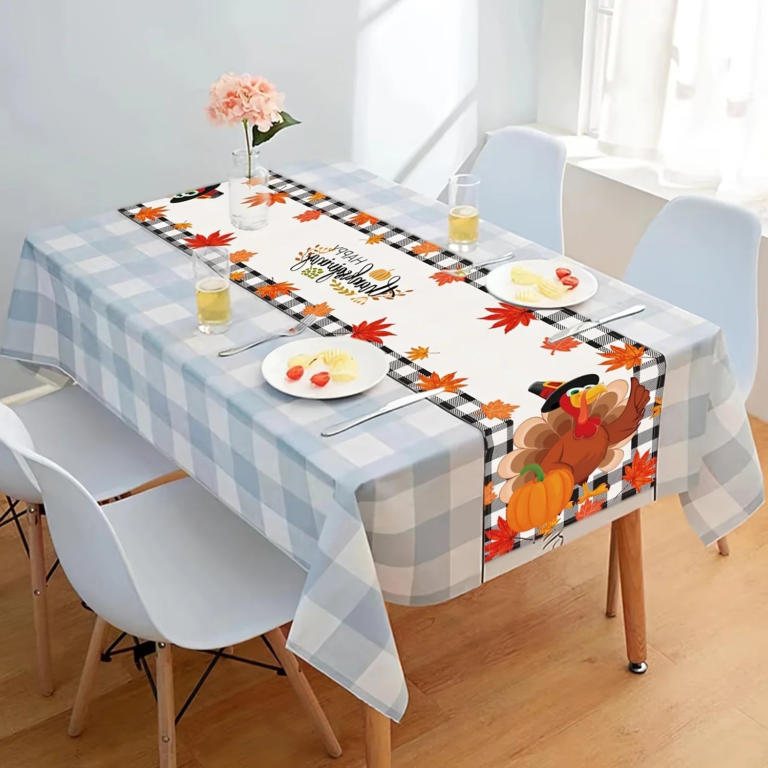 Une table de salle à manger décorée de manière chaleureuse et accueillante avec des motifs d'automne, des fleurs et des accessoires de cuisine.