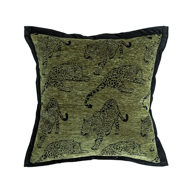 Coussin décoratif imprimé de motifs de léopards vert kaki sur fond noir.