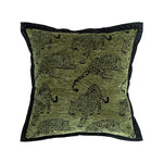 Coussin décoratif imprimé de motifs de léopards vert kaki sur fond noir.