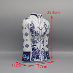 Vase de céramique blanc décoré de motifs floraux bleus avec des dimensions de 25,5 cm de hauteur, 17 cm de largeur et 11 cm de profondeur.