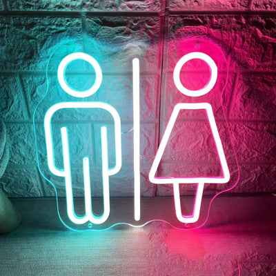 Enseigne au néon WC homme femme allumée en vert dans une salle de bain moderne