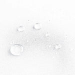 Gouttes d'eau sur tissu blanc, démonstration d'un traitement déperlant efficace pour protéger contre l'humidité et les taches. Image montrant la résistance à l'eau, idéale pour les produits nécessitant une protection supplémentaire.