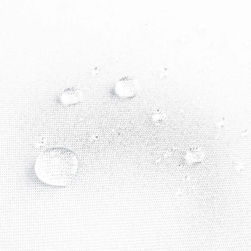Gouttes d'eau sur tissu blanc, démonstration d'un traitement déperlant efficace pour protéger contre l'humidité et les taches. Image montrant la résistance à l'eau, idéale pour les produits nécessitant une protection supplémentaire.