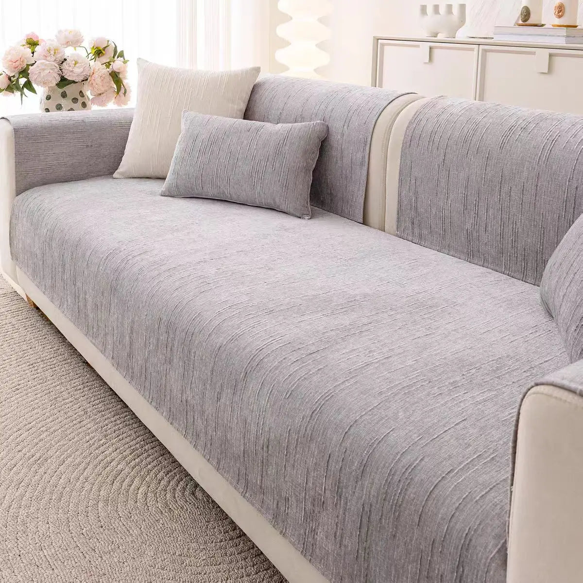 Un canapé gris confortable orné de coussins assortis dans un décor élégant et lumineux.