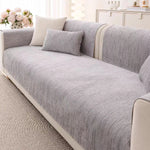 Un canapé gris confortable orné de coussins assortis dans un décor élégant et lumineux.