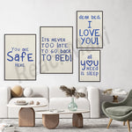 Cette image représente un salon avec des cadres muraux contenant des messages humoristiques et encourageants sur le sommeil et le bien-être. Le décor est moderne et épuré, avec des meubles en bois et en tissu clair.