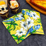 serviettes table papier motif tropical perroquets fleurs palmiers jaune bleu vert hibiscus pliées dépliées