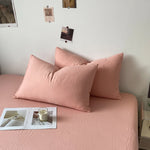 L'image montre un lit douillet et reposant avec des oreillers et une couverture dans une teinte rose pâle, créant une atmosphère apaisante et confortable.