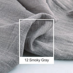 Cette image en noir et blanc montre un tissu chiffonné avec des plis et des ombres, donnant une texture et une ambiance douces et apaisantes dans une teinte grise légèrement fumée.