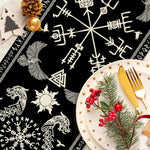 Cette image montre une belle assiette de Noël décorée avec des brindilles de sapin, des baies rouges et des couverts dorés posés sur un fond noir orné de symboles et motifs nordiques.