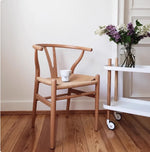chaise bois naturel tissu tressé scandinave tapis gris plante vase lampe salon balcon