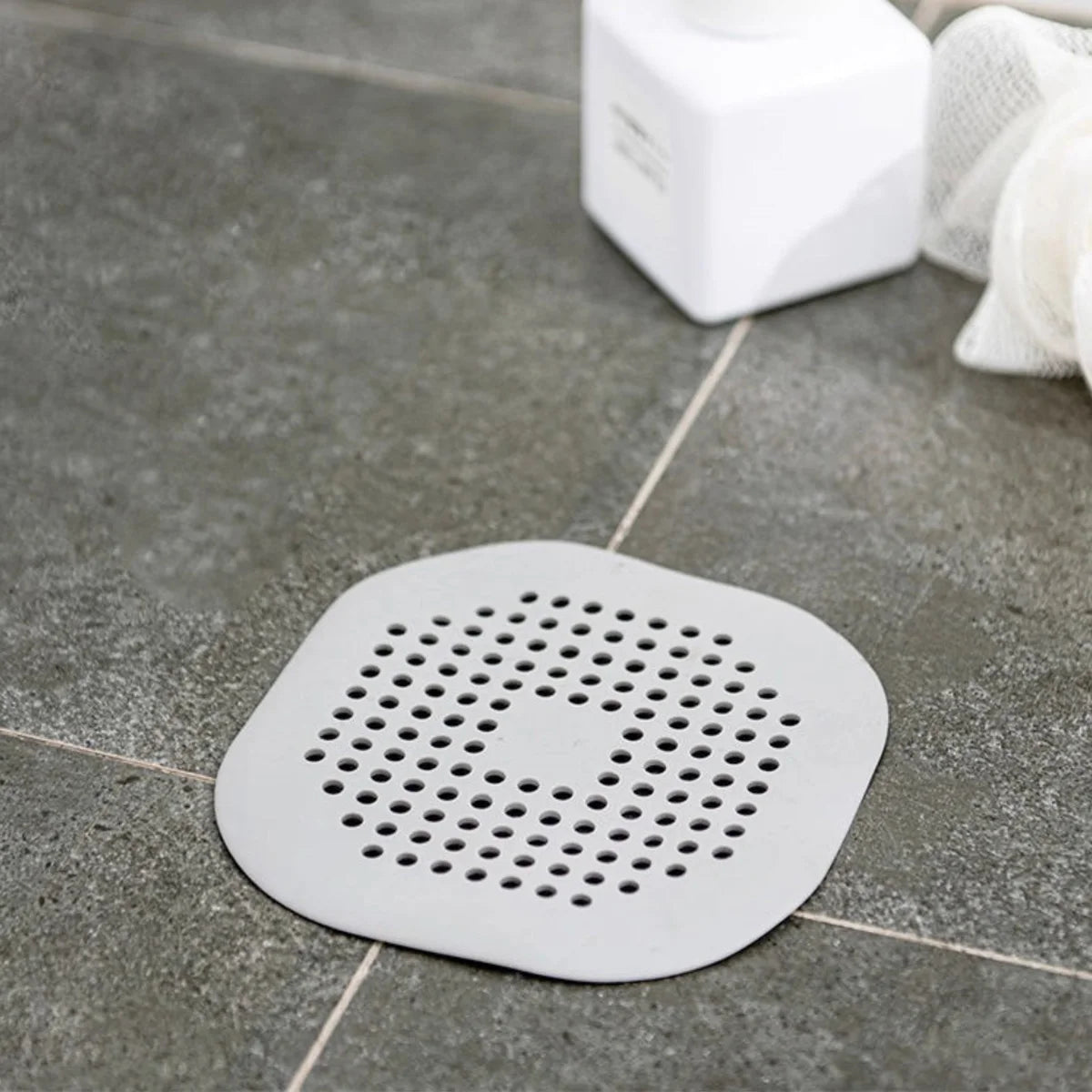 filtre bain réutilisable perforations géométriques adhésif blanc gris moderne respectueux environnement