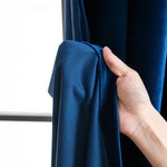 Rideau bleu installé sur fenêtre française