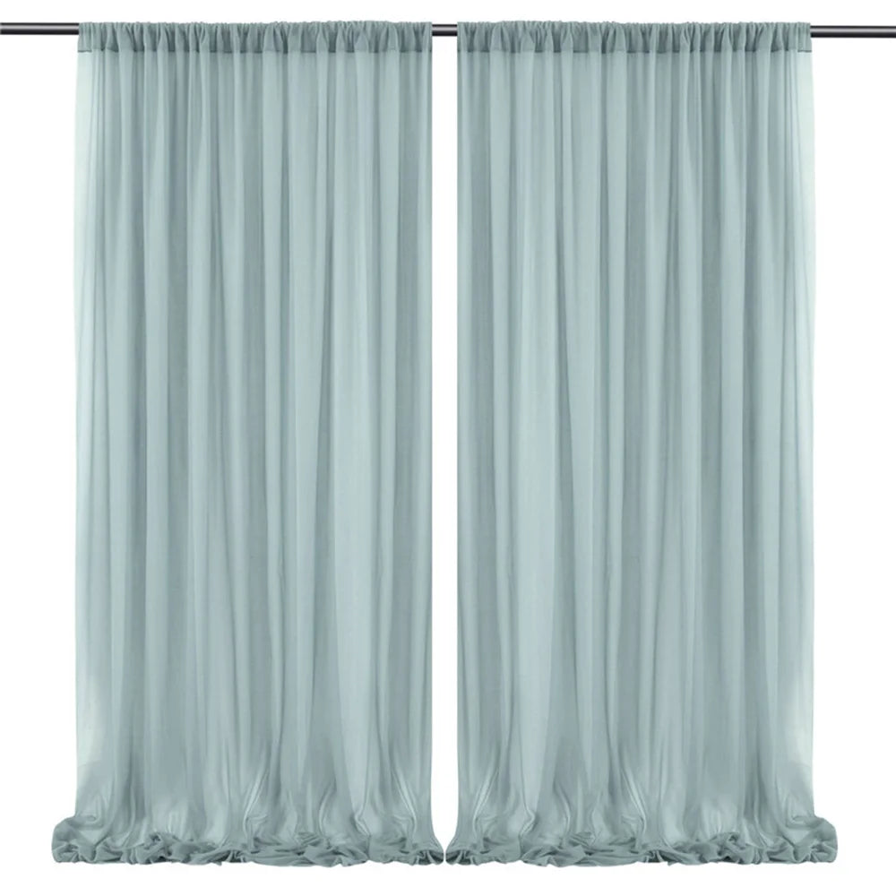 Rideaux soyeux de couleur bleu-vert pâle, suspendus sur une tringle à rideaux, créant une ambiance élégante et sereine dans la pièce.