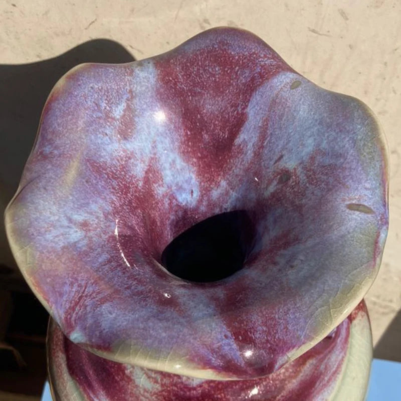 Cette image montre une donut de forme irrégulière avec une surface texturée et des nuances de pourpre et de rouge.