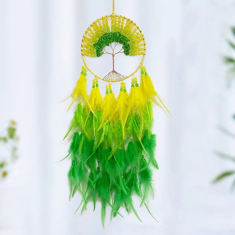 Une décoration de rêve attrayante en forme de cercle orné de plumes vertes et jaunes avec un arbre de vie au centre.