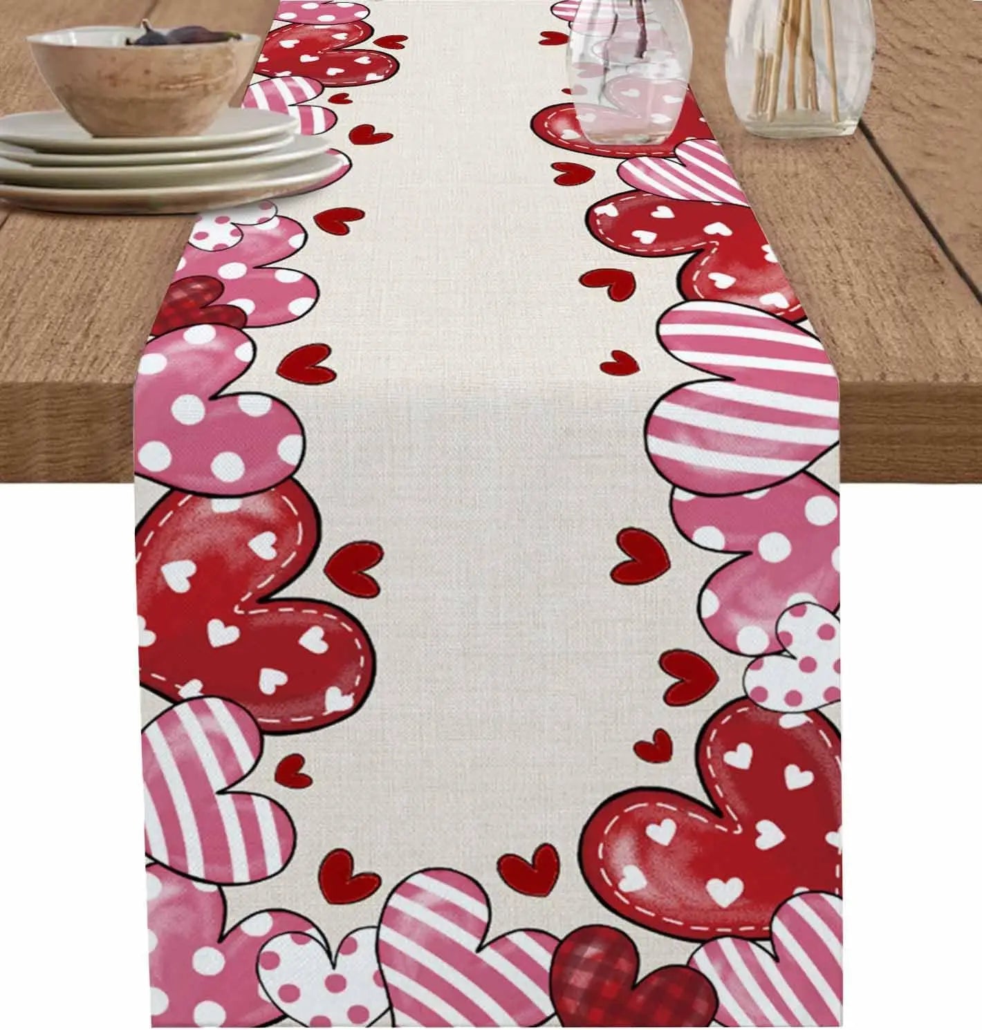Chemin de table décoré de motifs de cœurs, de pois et de rayures dans des tons de rose et de rouge, créant une atmosphère chaleureuse et romantique.