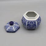 Pot en céramique décoratif hexagonal bleu et blanc avec couvercle, orné de motifs floraux traditionnels.